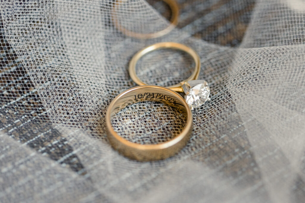 Close-up of wedding rings with a date engraving on a veil
